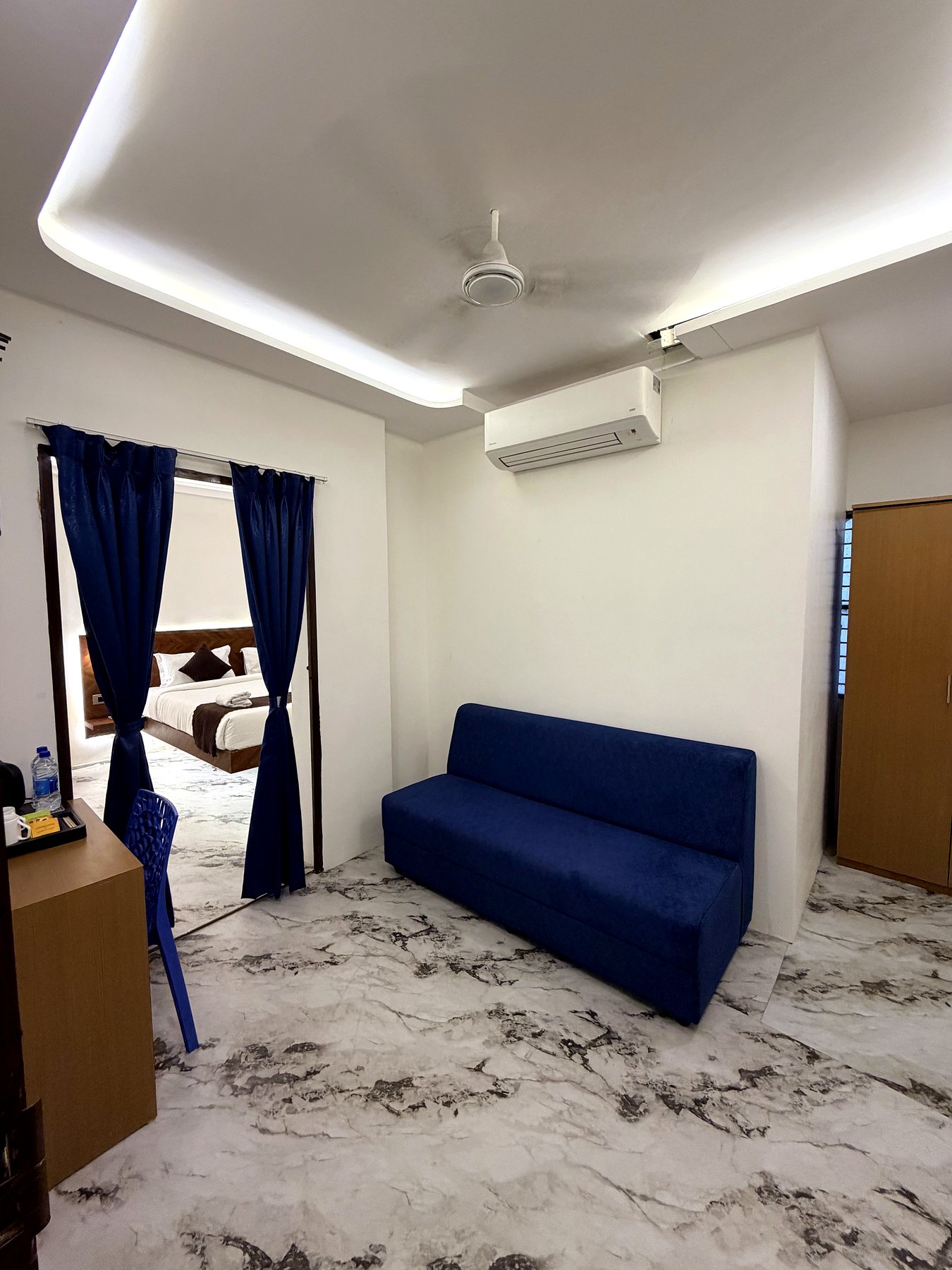 Suite lounge with blue sofa and connecting bedroom